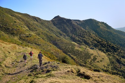 France, Cantal (15), Parc Naturel Régional des Volcans d'Auvergne, Le Lioran, randonneurs venant du col de Rombière sur le chemin de Saint-Jacques de Compostelle par la Via Arverna, le sommet du Téton de Venus au centre et le Rocher du Bec de l'Aigle à droite en arrière plan, le refuge du Buron de Meije Costes dominant la vallée de l'Alagnon