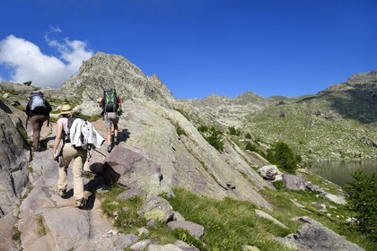 France, Alpes-Maritimes, parc national du Mercantour (Mercantour National Park), the Vallee des Merveilles (Valley of Wonders) scattered with thousands of rupestral engravings of the Bronze Age, hiking trail along Upper Lake Long and the Cime des Lacs (2510m) mountain in the background left