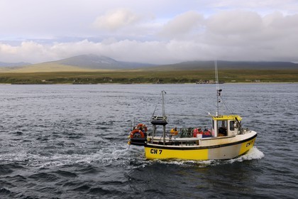 Royaume-Uni, Ecosse, Hébrides intérieures, Ile de Islay, bateau de pêche à Port Askaig et les montagnes de l'île de Jura en arrière plan