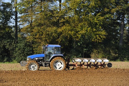 France, Seine Maritime, Varengeville sur Mer, plowing a field near the forest