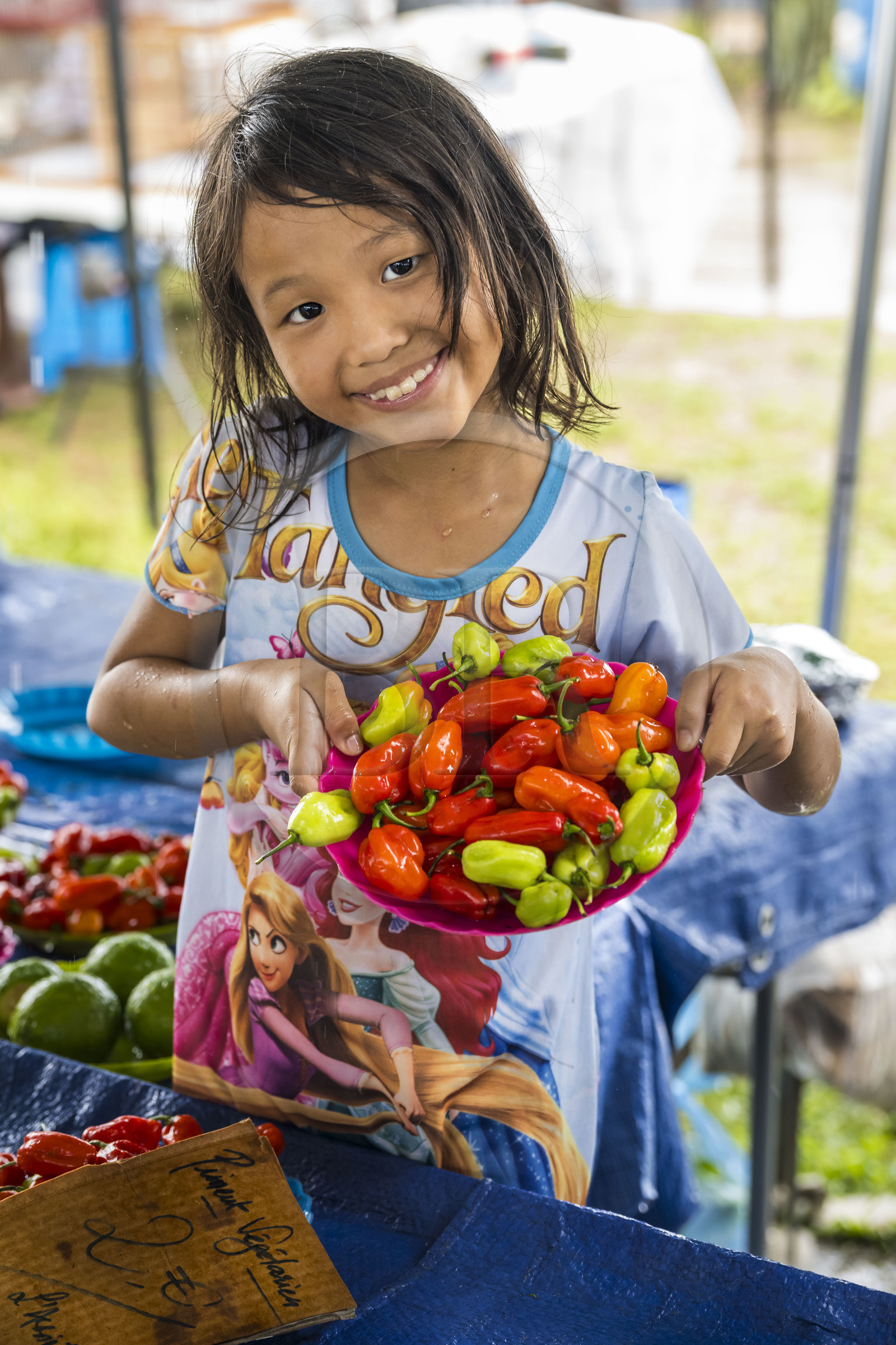 France, Guyane, Javouhey, marché du dimanche Hmong, réfugiés du Laos arrivés en 1978 qui se sont spécialisés dans la culture fruitière, Nancy, 7 ans, présente les produits de l'étal de ses parents