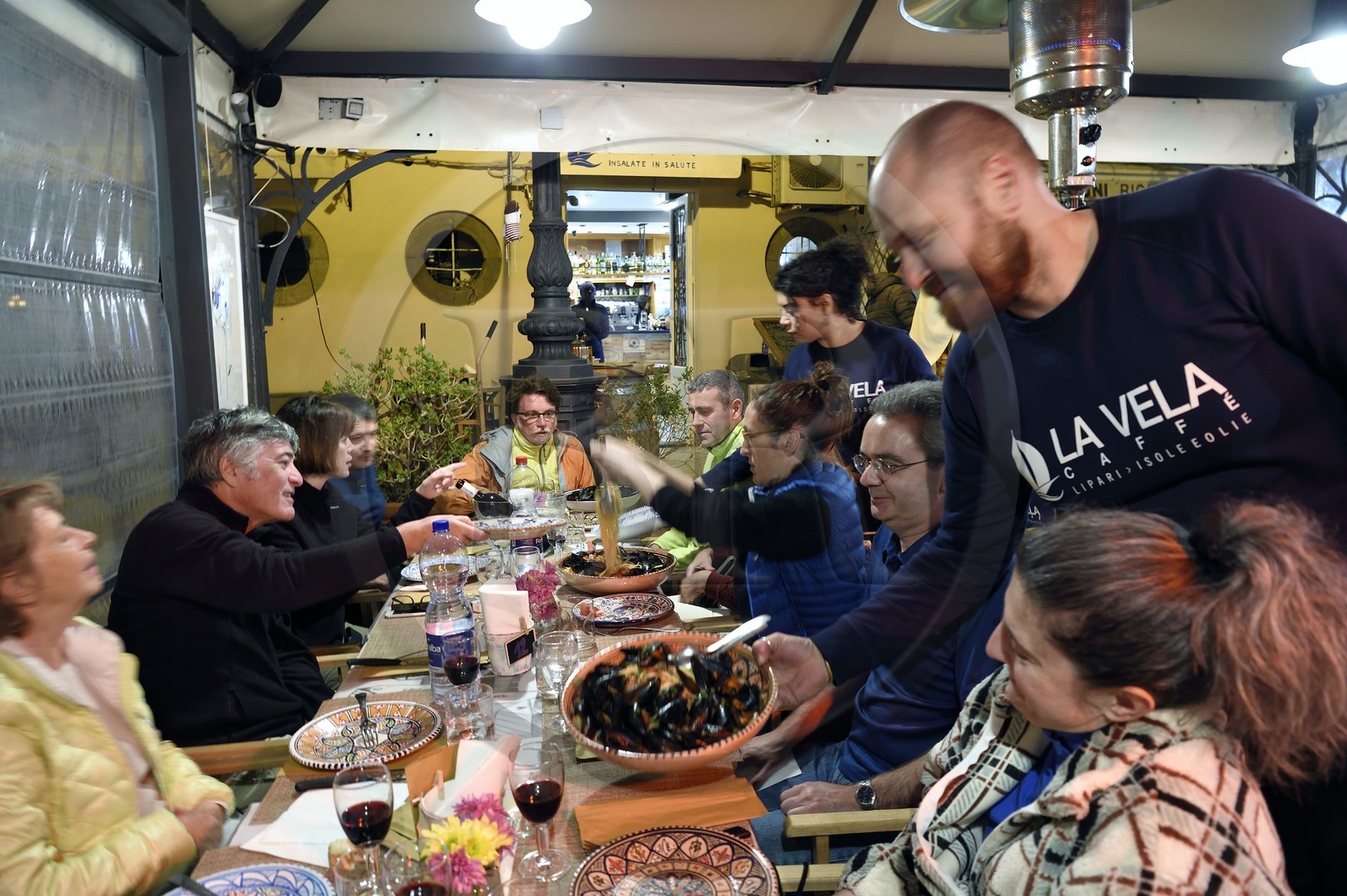 Italie, Sicile, iles Eoliennes, classées Patrimoine Mondial de l'UNESCO, Ile de Lipari, Lipari, groupe de randonneurs au restaurant La Vela sur le port de pêche de Marina Corta