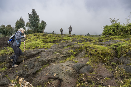 Rwanda, Province du Nord, District de Musanze (Ruhengeri), garde et pisteur du Parc accompagnant une randonneuse sur les pentes volcaniques du mont Karisimbi dans les montagnes des Virunga en bordure du Parc national des Volcans où vivent les gorilles