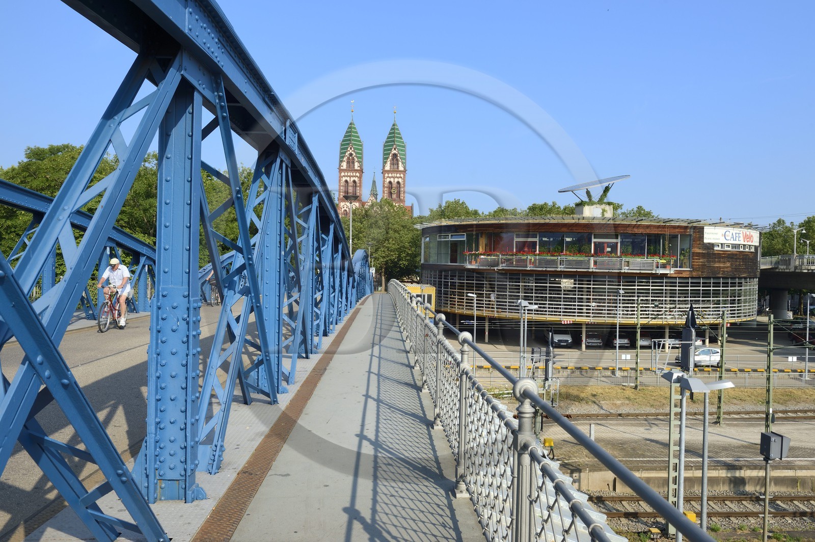 Allemagne, Bade-Wurtemberg, Fribourg en Brisgau, cycliste sur le pont bleu (pont Wiwili) , l'église du Sacré-Coeur de Jésus (Herz-Jesu-Kirche) et la station à vélos Mobile à droite en arrière-plan