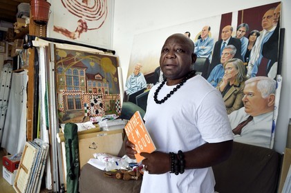 France, Paris (75), Barthelemy Toguo, l'artiste fondateur de Bandjoun Station au Cameroun (représenté dans la peinture en arrière plan), dans son atelier parisien