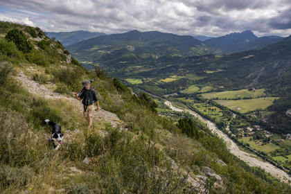 France, Drome, regional natural park of Baronnies provencales, Remuzat, Christian Tessier, director of the Vautours en Baronnies association, goes to observe griffon vultures on the Saint-Laurent plateau with a telescope over his shoulder above the Oule river valley
