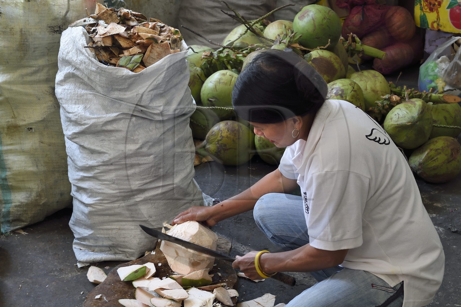 Philippines, province d'Ifugao, découpe d'une noix de coco dans le marché de la ville de Banaue