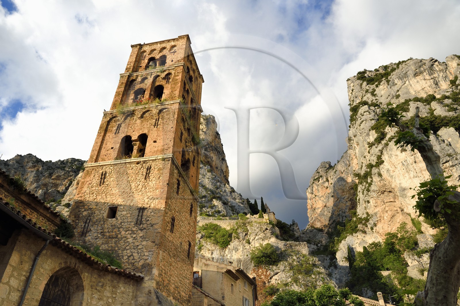 France, Alpes-de-Haute-Provence (04), Parc Naturel Régional du Verdon, Moustiers-Sainte-Marie, labellisé Les Plus Beaux Villages de France, l'église Notre-Dame-de-l'Assomption avec son clocher du XIIe siècle en tuff et l'Etoile de Moustier accrochée à une chaîne à plusieurs dizaines de mètres au-dessus du sol