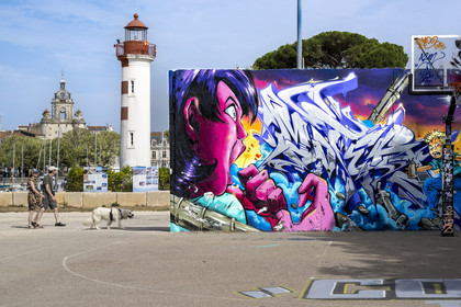 France, Charente Maritime, La Rochelle, the Old Port lighthouse the red lantern in the Gabut district and street art on the basketball court