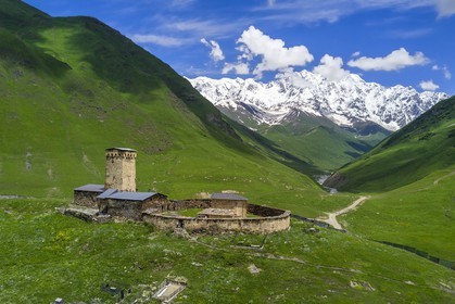 Georgia, Upper Svaneti (Zemo Svaneti), village of Ushguli, listed as World heritage by UNESCO, Lamaria St. Mary's church of Ushguli from the 12th century and Mount Chkhara (highest peak in Georgia with 5193 m) in the background (aerial view)
