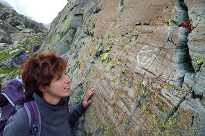 France, Alpes-Maritimes, parc national du Mercantour (Mercantour National Park), the Vallee des Merveilles (Valley of Wonders) scattered with thousands of rupestral engravings of the Bronze Age, the archaeologist Nicoletta Bianchi studies the hornlike anthropomorphized figure engraved on the so called rock of the Christ