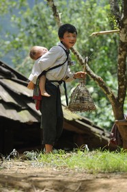 Vietnam, Lao Cai province, Sapa district, Ta Phin valley, young boy from the Black Hmong minority group holding a birdcage