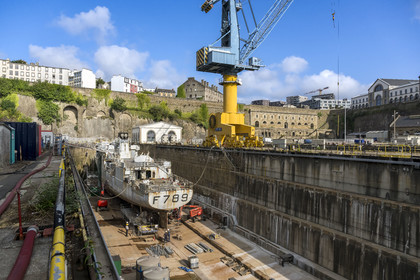 France, Finistère (29), Brest, l'arsenal, le port militaire est une base navale de la Marine nationale, navire de guerre en chantier dans un des deux bassins de radoub de Pontaniou situés dans l’anse de Pontaniou, le batiment aux Lions en arrière plan à droite