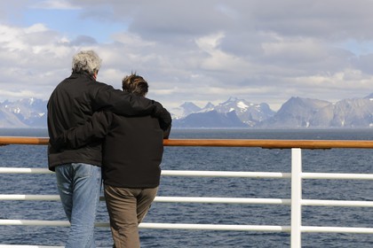 Greenland, Southern Region, cruise ship Princess Danae passing of Farvel (Farewell) Cape, couple watching the coast