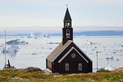 Groenland, cote ouest, baie de Disko, Ilulissat, église de Sion construite à la fin du XVIIIe siècle et icebergs en arrière plan