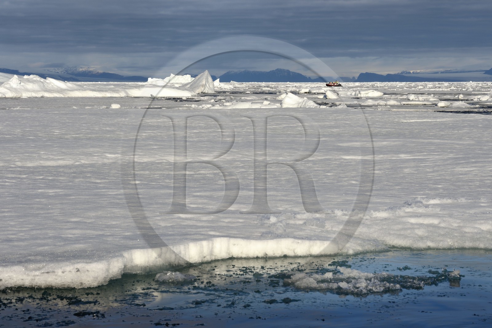 Groenland, cote Nord-Ouest, Smith sound au nord de la baie de Baffin, morceaux de glace de la banquise arctique en train de fondre et un PolarCirkel boat (zodiac) d'exploration du bateau de croisière MS Fram de la compagnie Hurtigruten, iceberg géant en arrière plan vers la côte canadienne de l'ile d'Ellesmere