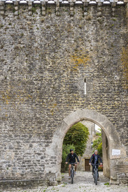 France, Aveyron, Grands Causses regional natural park, cyclists on the Brebis'Cyclette tourist cycle route in the Roquefort region, the Cistercian fort of Saint-Jean-d’Alcas
