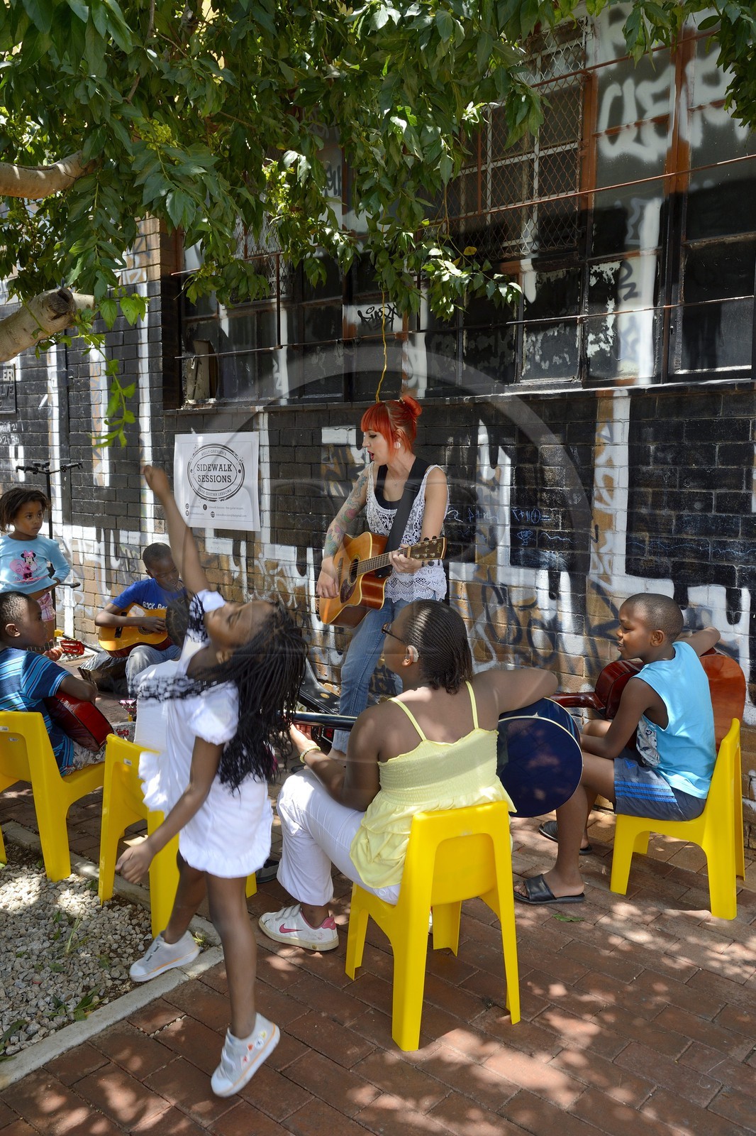 Afrique du Sud, province de Gauteng, Johannesburg, CBD (Central Business District), quartier de Maboneng, Sidewalk Sessions dans Fox street, Kelly Grevler donne des cours de guitare gratuits pour de jeunes enfants dans la rue
