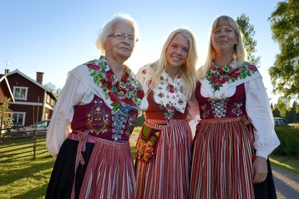 Suède, comté de Dalécarlie, région de Leksand, célébrations du solstice d'été dans le petit hameau de Hjulbäck, trois femmes en costumes traditionnels, grand-mère, mère et fille