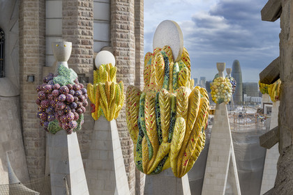 Espagne, Catalogne, Barcelone, quartier de l'Eixample, basilique de la Sagrada Familia de l'architecte du modernisme catalan Antoni Gaudi classée Patrimoine Mondial de l'UNESCO, sommets surmontés de mosaïques en forme de fruits, la Torre Agbar de l'architecte Jean Nouvel en arrière plan
