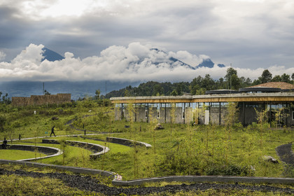 Rwanda, Province du Nord, District de Musanze (Ruhengeri), Kinigi, Campus Ellen DeGeneres du Dian Fossey Gorilla Fund par l'architecte MASS Design Group, le batiment du Rob and Melani Walton Education Center, le Mont Karisimbi à gauche et le Mont Visoke au centre puis le Mont Mikeno (situé au Congo) à droite en arrière plan