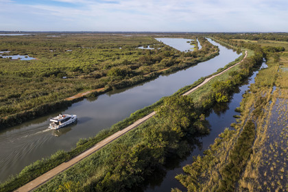 France, Gard (30), la Petite Camargue, navigation d'un bateau de plaisance Le Boat sur le canal du Rhône à Sète entre Gallician et Aigues-Mortes (vue aérienne) France, Gard, the Petite Camargue, navigation of a pleasure boat Le Boat on the Rhone to Sète Canal between Gallician and Aigues-Mortes (aerial view)