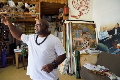 France, Paris (75), Barthelemy Toguo, l'artiste fondateur de Bandjoun Station au Cameroun (représenté dans la peinture en arrière plan), dans son atelier parisien