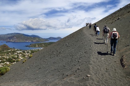 Italie, Sicile, iles Eoliennes, classées Patrimoine Mondial de l'UNESCO, ile de Vulcano, randonneurs dans l'ascension du cratère du volcan della Fossa, l'Ile de Lipari en arrière plan