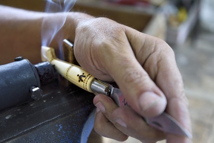 France, Dordogne, Périgord Vert, Nontron, manufacturing knives in the Coutellerie Nontronaise Factory, pattern of the handle pyrography