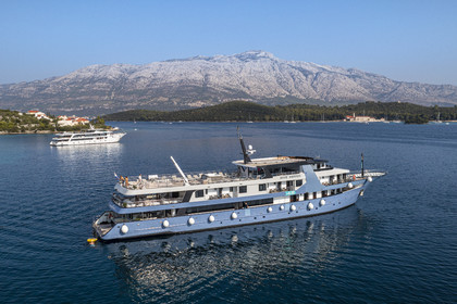 Croatia, Dalmatia, Dalmatian coast, anchoring of a cruise ship in the Skoji archipelago on the edge of Korcula Island, the Franciscan monastery on Badija Island in the background (aerial view)