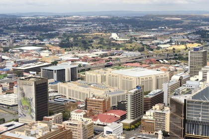 South Africa, Gauteng Province, Johannesburg, CBD (Central Business District), downtown view from the Carlton Center tower, the Standard Bank headquarters and the Soccer City Stadium in Soweto in the background