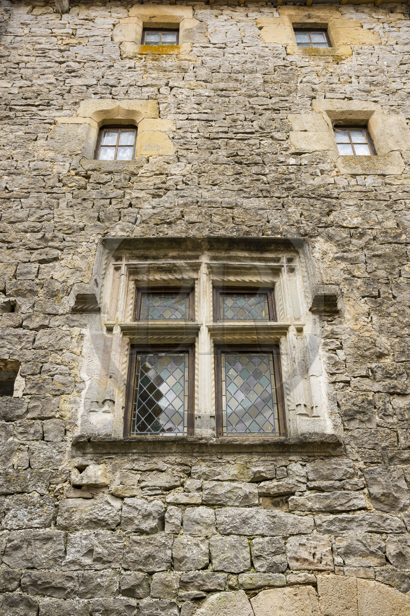 France, Aveyron, Grands Causses regional natural park, the Cistercian fort of Saint-Jean-d’Alcas, the Grenier de la Rente house was once used to store the royalties of the Abbess of Nonenque, Renaissance casement window on the facade of medieval house typical of Caussenarde architecture