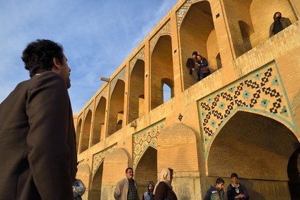 Iran, Isfahan Province, Isfahan, Khaju Bridge on the Zayandeh river, couple of lovers listening to a singer