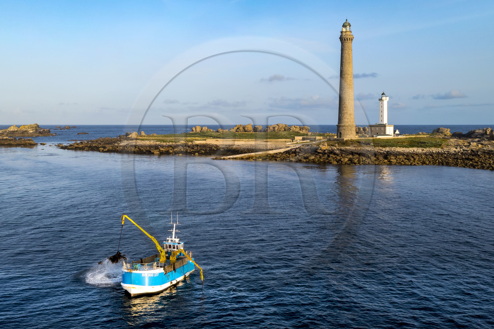 France, Finistère (29), Pays des Abers, Ile Vierge dans l'archipel de Lilia, bateau goémonier utilisant un de ses deux bras mécaniques articulés se terminant par un scoubidou pour récolter des algues marines le goémon, le phare de l'Ile Vierge en arrière plan (vue aérienne)
