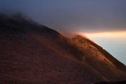 Italie, Sicile, iles Eoliennes, classées Patrimoine Mondial de l'UNESCO, ile de Stromboli, fumerolles d'une éruption et chute de bombes de lave sur les pentes du volcan actif au coucher de soleil