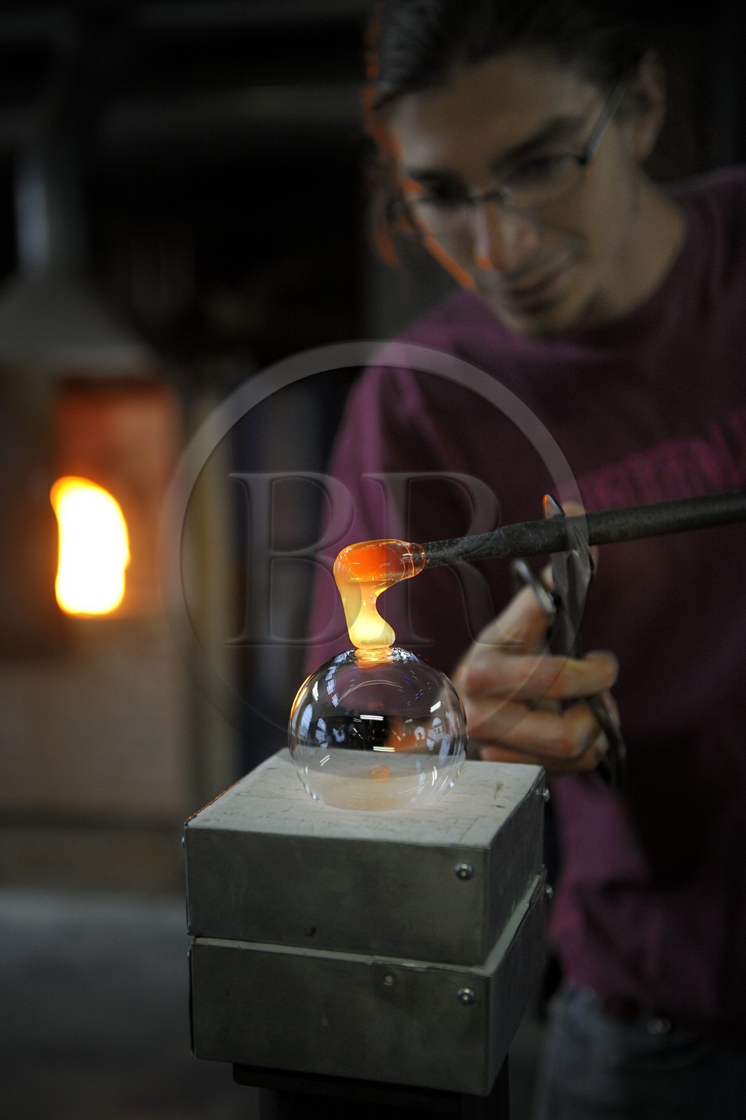 France, Moselle (57), Meisenthal, Thibaut souffleur au Centre international d’Art verrier (CIAV), fabrication d'une boule de Noël en verre. Avec du verre en fusion, il colmate directement le trou – l’impact où la boule a été soufflée