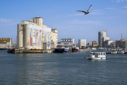 France, Vendée (85), Les-Sables-d'Olonne, bac traversant le port, fresque retracant l'histoire de la ville peinte sur les silos de la coopérative Cavac par l'artiste basque Taroe en arrière plan