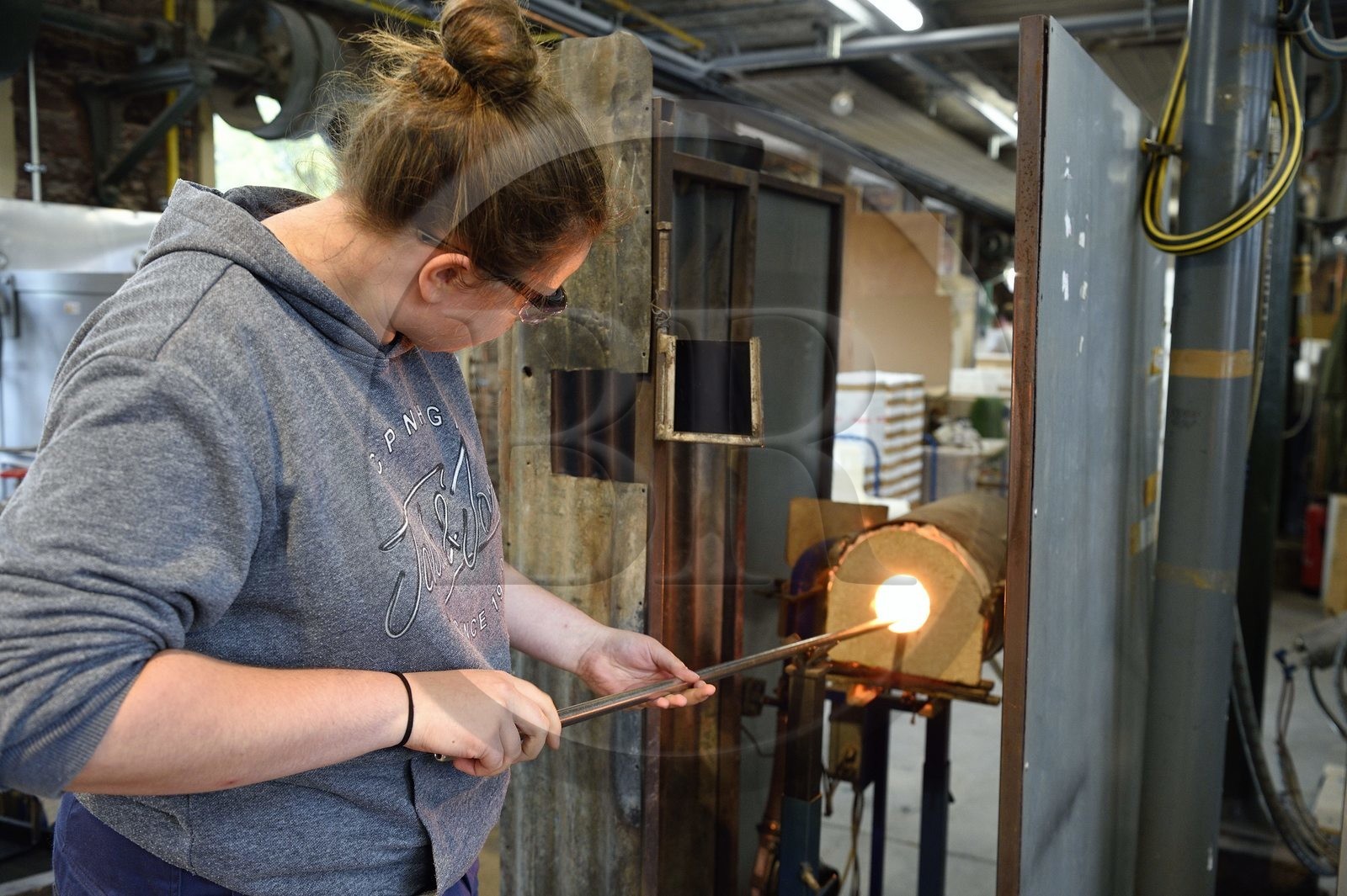 France, Moselle (57), Meisenthal, Centre international d’Art verrier (CIAV), l'atelier de soufflage, fabrication artisanale d'une boule de Noël, le souffleur recueille dans le four une masse de verre en fusion avec sa canne de verrier France, Moselle (57), Meisenthal, Centre international d’Art verrier (CIAV), l'atelier de soufflage, fabrication artisanale d'une boule de Noël, le souffleur recueille dans le four une masse de verre en fusion avec sa canne de verrier