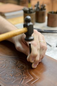 Argentina, Buenos Aires Province, San Antonio de Areco, workshop of the leather craftsman Martin Alvarez hammering the leather of a saddle piece