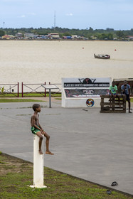 France, French Guiana, Saint-Laurent-du-Maroni, redeveloped riverbanks of the La Charbonnière district with its Bushinengue roots and a boat on the Maroni River, the natural border with Suriname in the background