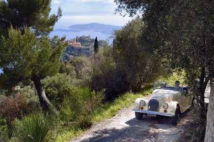 France, Alpes Maritimes, discovering the coast in a Morgan Roadster 4 4 vintage car, here on a road overlooking the hilltop village of Eze, Saint Jean Cap Ferrat in the background