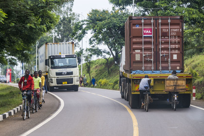 Rwanda, Province de l’Est, Rwamagana, cyclistes se tenant au cul des camions pour se faire tracter, les bicyclettes sont le principal moyen de transport local