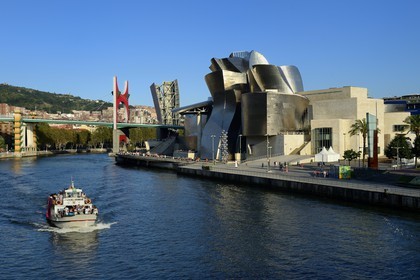 Spain, Basque Country Region, Vizcaya Province, Bilbao, the Guggenheim Museum designed by Frank Gehry and the Salve bridge with Les Arches Rouges artpiece by French artist Daniel Buren in the background