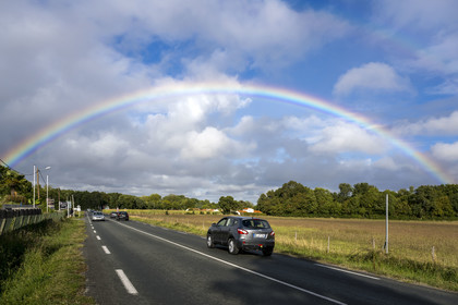 France, Charente-Maritime, Royan region, road framed by a rainbow