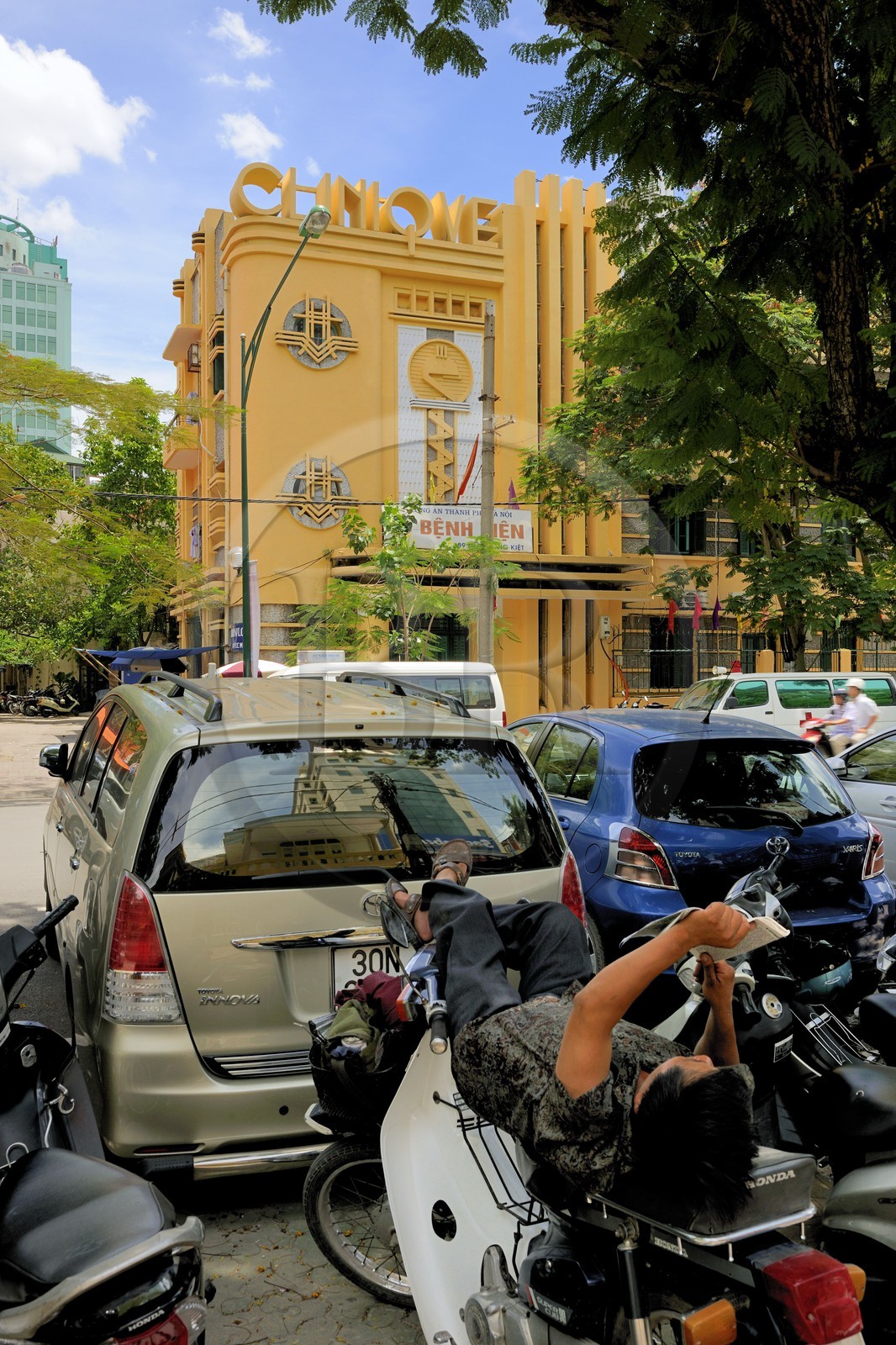 Vietnam, Hanoï, quartier de la gare centrale, sieste sur une moto devant la clinique art déco construite en 1936 pour la SNCF rue Ly Thuong Kiet