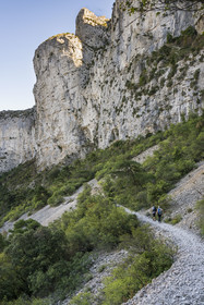 France, Hérault (34), Causses et les Cévennes, paysage culturel de l'agro-pastoralisme méditerranéen, classés Patrimoine Mondial de l'UNESCO, Saint-Guilhem-le-Désert, labellisé Les Plus Beaux Villages de France, randonneurs sur la Via Tolosana sur le Chemin de Saint-Jacques-de-Compostelle sous les falaises dans le cirque de l'Infernet