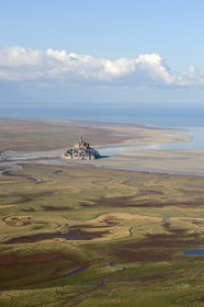 France, Manche, Bay of Mont Saint Michel, listed as World Heritage by UNESCO, Mont Saint Michel; salt meadows and sea arm at low tide in the foreground (aerial view)