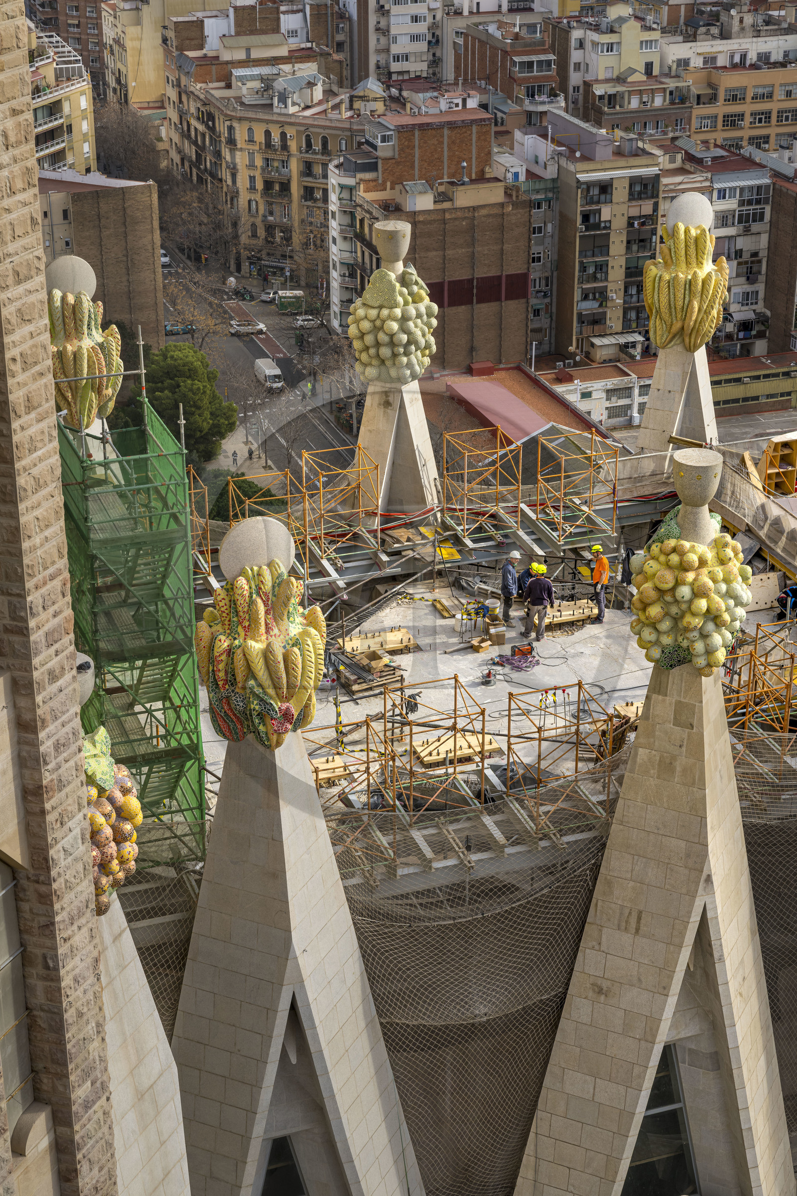 Espagne, Catalogne, Barcelone, quartier de l'Eixample, basilique de la Sagrada Familia de l'architecte du modernisme catalan Antoni Gaudi classée Patrimoine Mondial de l'UNESCO, sommets surmontés de mosaïques en forme de fruits entourant le chantier sur le toit de la nef à l'arrière de la future facade de la Gloire