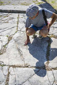 France, Vaucluse (84), Vaison-la-Romaine, site archéologique de la Villasse, Jean-Marc Mignon, archéologue et attaché principal de conservation du patrimoine du Vaucluse, pointe les traces de chariots sur les dalles de la rue des boutiques