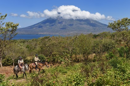 Nicaragua, Ometepe Island in Lake Nicaragua, riders trekking and the Conception volcano (1610 m) still active in the background